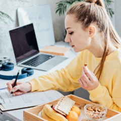 a professional woman eating healthy snacks while working